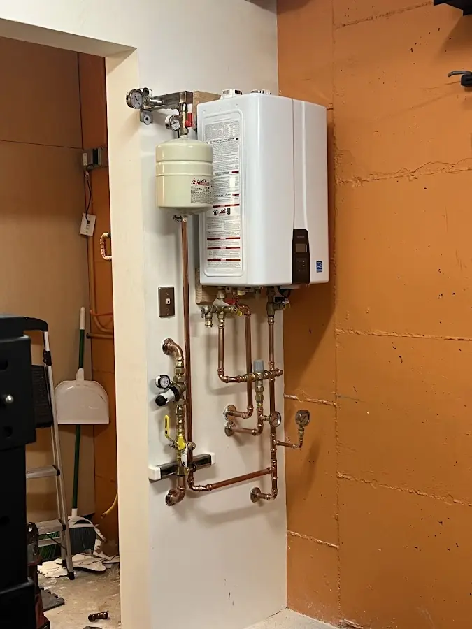 Plumbing technician inspecting water heater connections in Hazel Crest